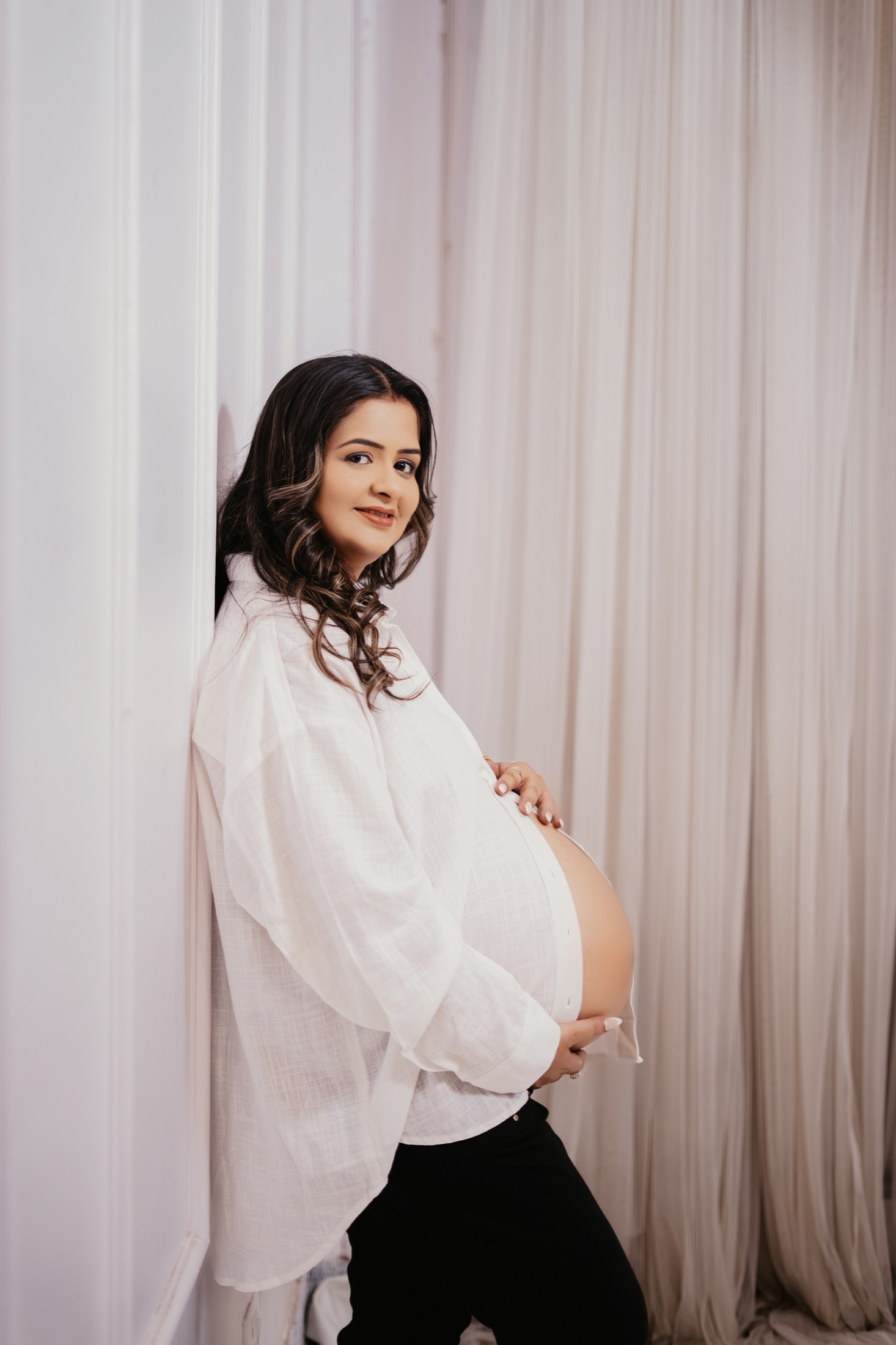 Maternity white curtain baby bump portrait