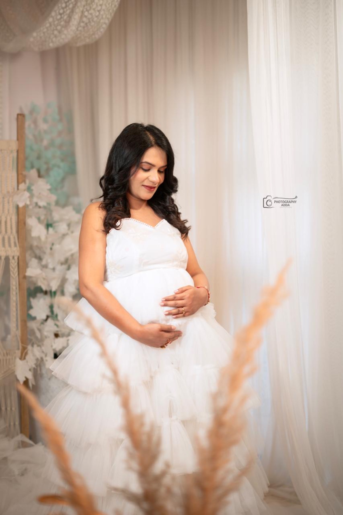Soft white maternity studio portrait with pampas foreground